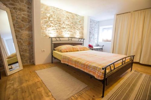 a bedroom with a bed and a stone wall at Holiday house with a parking space Kraj, Pasman - 22391 in Kraj