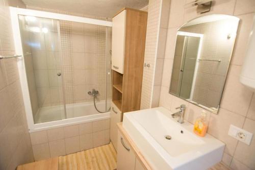 a bathroom with a sink and a mirror and a tub at Holiday house with a parking space Kraj, Pasman - 22391 in Kraj