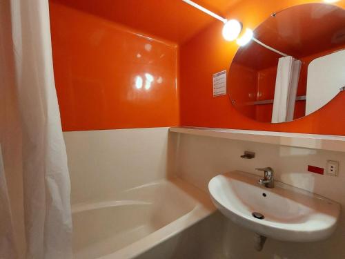 La salle de bains orange est pourvue d'un lavabo et d'un miroir. dans l'établissement Résidence Belles Challes - Studio 4 personnes à Arc 1800 skis aux pieds et proche des commerces dans le village du Charvet MAE-1799, à Arc 1800