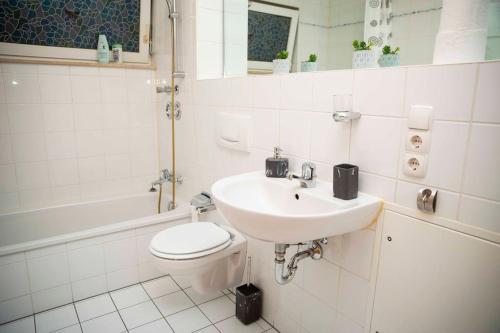 a white bathroom with a sink and a toilet at Deluxe Apartment in Kahl am Main