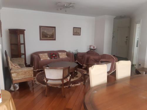 ein Wohnzimmer mit einem Sofa, einem Tisch und Stühlen in der Unterkunft Habitación individual Business in Quito