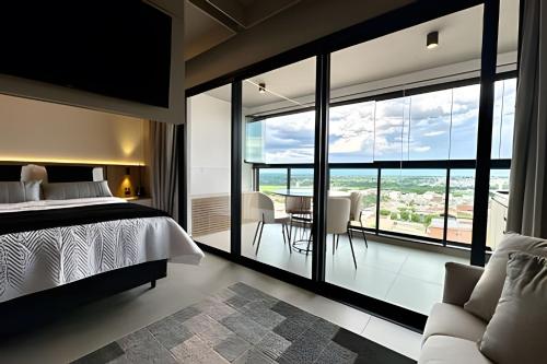 a bedroom with a bed and a large window at Studio C9 de alto padrão in Marília
