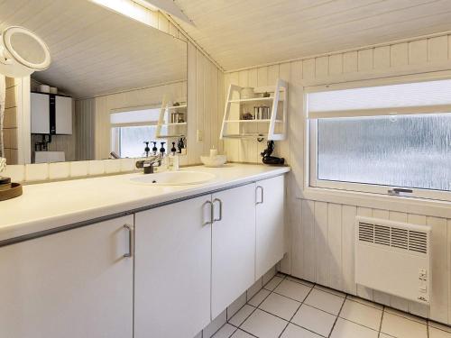 La salle de bains blanche est pourvue d'un lavabo et d'une fenêtre. dans l'établissement Holiday home Fjerritslev XIX, à Fjerritslev