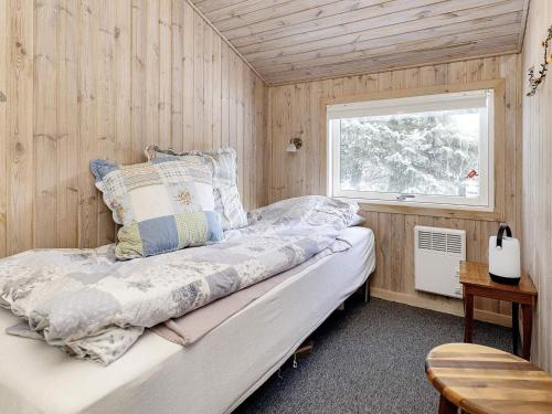 una camera con un letto su una parete in legno di Holiday home Fjerritslev XIX a Fjerritslev