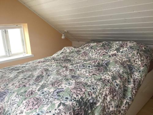 Bett mit Blumendecke in einem Schlafzimmer in der Unterkunft Holiday home Nysted VIII in Nysted