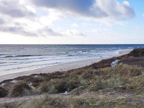 a beach with the ocean on a cloudy day at Holiday home Aakirkeby VIII in Vester Sømarken