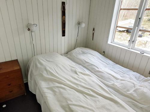 a white bed in a room with a window at Holiday home Aakirkeby VIII in Vester Sømarken