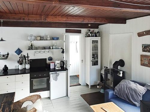 a kitchen with a stove and a refrigerator in a room at Holiday home Aakirkeby VIII in Vester Sømarken