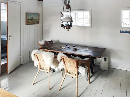 a dining room with a wooden table and chairs at Holiday home Aakirkeby VIII in Vester Sømarken