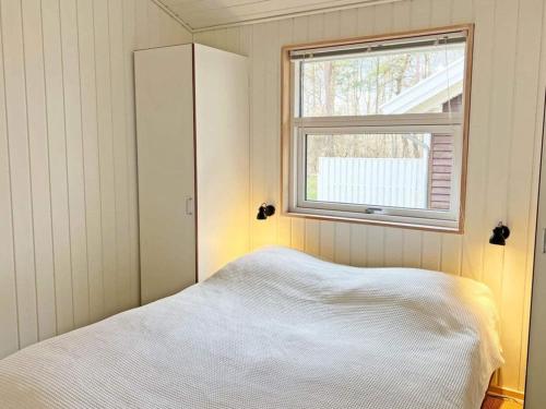 a small bedroom with a bed and a window at Holiday home Hasle CIX in Hasle