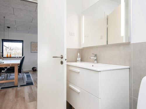 eine weiße Küche mit einem Waschbecken und einem Tisch in der Unterkunft Holiday home Sydals C in Sønderby