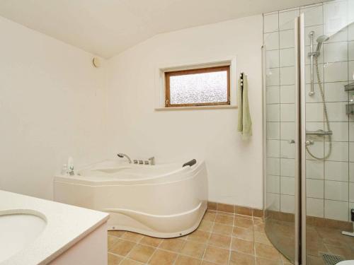 ein Bad mit einer Badewanne, einem Waschbecken und einer Dusche in der Unterkunft Holiday home Frederiksværk XV in Frederiksværk