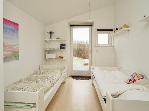 2 Betten in einem Zimmer mit Fenster in der Unterkunft Holiday home Frederiksværk XV in Frederiksværk