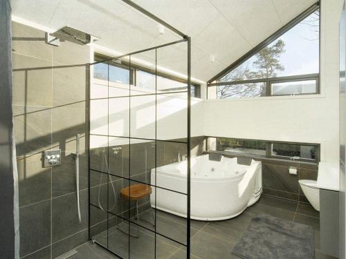 baño con bañera y pared de cristal en Holiday home Frederiksværk X, en Frederiksværk