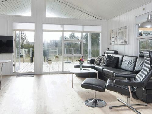 a living room with a leather couch and a table at 4 star holiday home in Juelsminde-By Traum in Sønderby