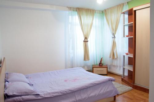 a bedroom with a bed and a window with curtains at Apartament Central Onix in Braşov