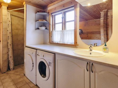 a bathroom with a sink and a washing machine at Holiday home Læsø XII in Læsø