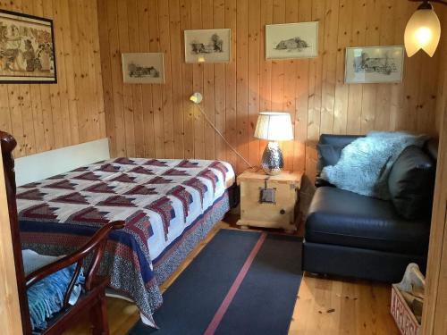ein Schlafzimmer mit einem Bett, einem Sofa und einer Lampe in der Unterkunft Holiday home Struer XXIX in Struer