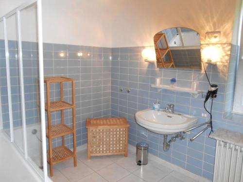 a blue tiled bathroom with a sink and a mirror at Holiday apartment dream view 2 in Monschau
