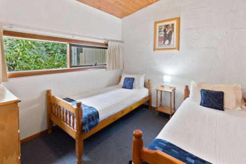 1 dormitorio con 2 camas y ventana en Clarendon Chalets, en Mount Gambier