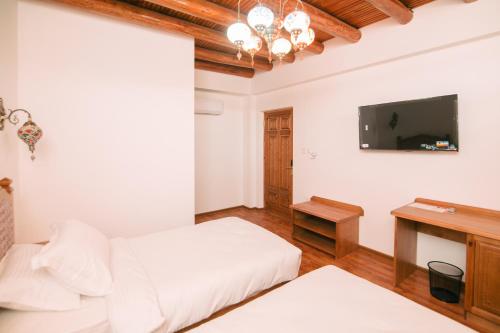 布哈拉的住宿－Istat Boutique Hotel，卧室配有白色的床和电视