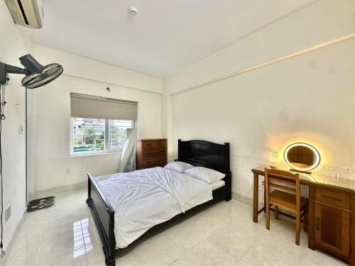 a bedroom with a bed and a desk with a mirror at SARAH HOMESTAY in Thôn Lại Thê