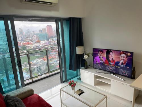 - un salon avec une télévision et une grande fenêtre dans l'établissement Summer suites klcc by Peaceful Nest, à Kuala Lumpur