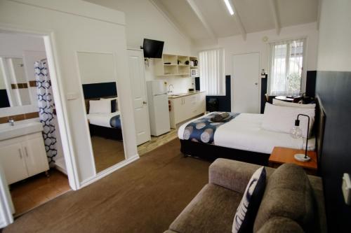 a hotel room with a bed and a couch at Canberra Ave Villas in Queanbeyan