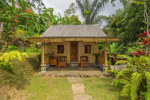 una pequeña casa en medio de un jardín en Pesona Bali Ecolodge, en Jatiluwih