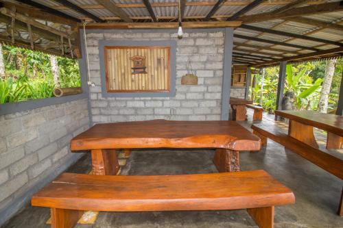 a wooden table and benches in a room at Pesona Bali Ecolodge by AGATA in Jatiluwih