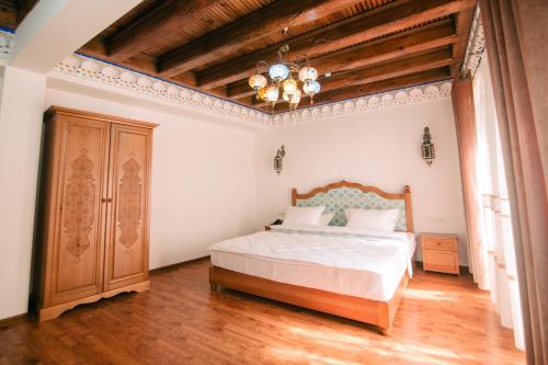 a bedroom with a bed and a chandelier at Istat Boutique Hotel in Bukhara
