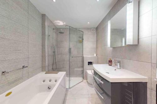 a bathroom with a tub and a sink and a shower at Stunning, CastleView, Riverside, Modern Townhouse in Eton
