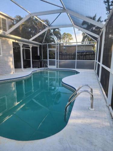 a swimming pool with a canopy and a swimming pool at Secluded Backyard Home with Hot Tub & Pool - 3BR & 2B in Fort Myers