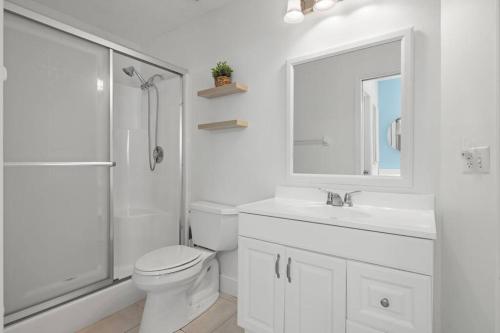 a white bathroom with a toilet and a sink at Secluded Backyard Home with Hot Tub & Pool - 3BR & 2B in Fort Myers