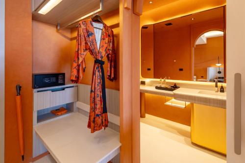 a bathroom with a sink and a robe hanging on a wall at Hotel Adam Krabi in Ao Nang Beach