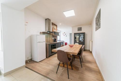 une cuisine avec une table et des chaises en bois dans l'établissement Le Gué Sourdeau: 150m² 5 min from Futuroscope, à Chasseneuil-du-Poitou