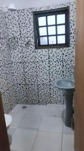 La salle de bains est pourvue d'une douche, d'un lavabo et d'une fenêtre. dans l'établissement Casa da Vila Encantada, à São Thomé das Letras