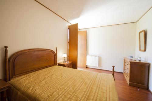 a bedroom with a large bed and a dresser in it at Casa Praia e Campo in Viana do Castelo