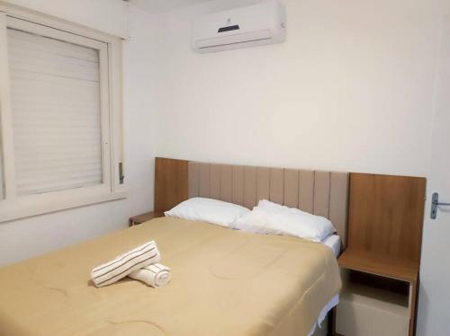 1 dormitorio con 1 cama con 2 toallas en Ótimo AP Consulado Americano, Iguatemi e Fiergs, en Porto Alegre