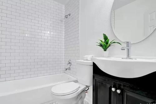 uma casa de banho com um WC, um lavatório e um espelho. em Charming Home 5 Min From Downtown & At&t Center em San Antonio