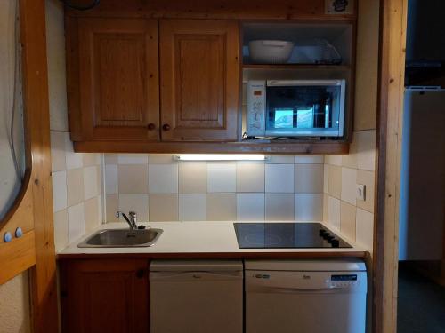 une petite cuisine avec un évier et un micro-ondes dans l'établissement Résidence Nova - Appartement 2 pièces 6 personnes proche des pistes, des commerces, de la garderie et de l'ESF au centre de la station d’Arc 1800 MAE-2042, à Arc 1800