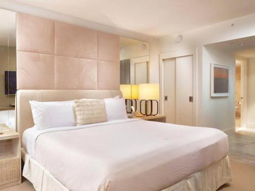 1 cama blanca grande en una habitación grande con 2 lámparas en Oceanview 1 Hotel & Homes 1 Bedroom 1 and Half Bathrooms Luxe Condo with Balcony, en Miami Beach