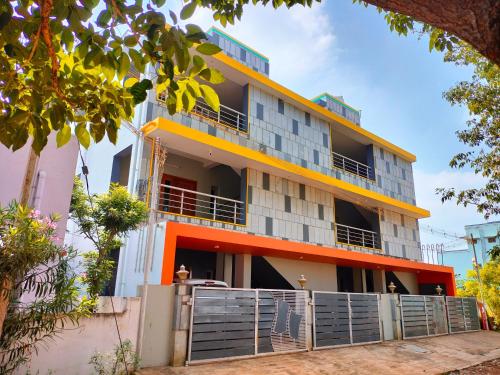 un edificio de apartamentos de color naranja y blanco en Naadi Nest - 2 Bedroom Service Apartment, en Thanjāvūr