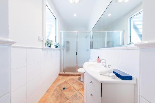 a white bathroom with a sink and a shower at Gaslight Inn - Adults Only in Sydney