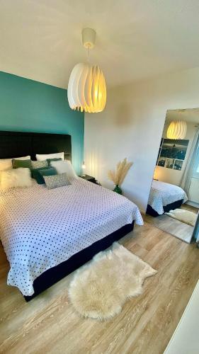 - une chambre avec un lit blanc et un mur bleu dans l'établissement Superbe Chambre avec vue et salle d eau privative dans duplex de 140m2 - proche CHU Clermont, à Beaumont