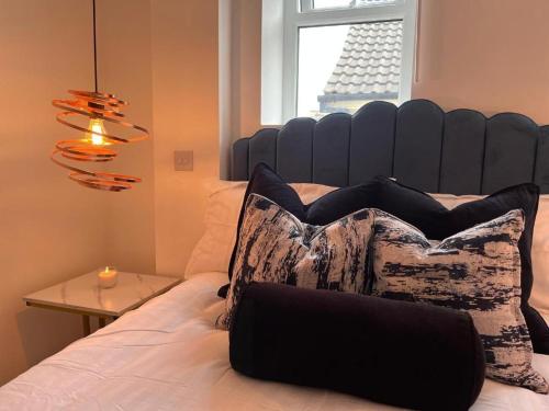 uma cama com uma cabeceira azul com uma almofada em Manhattan Luxury Suites em Bradford