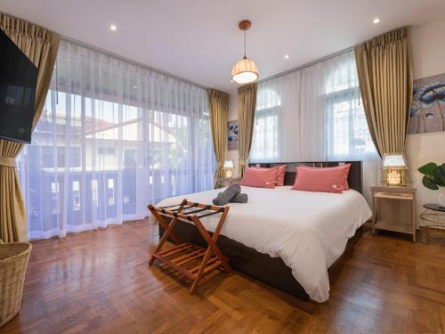 a bedroom with a large bed and large windows at Large Pool Villa (440 SQM) Near ThongLor BTS. 4 Bedrooms/4.5 Baths. FREE Airport Pickup Service. in Bangkok