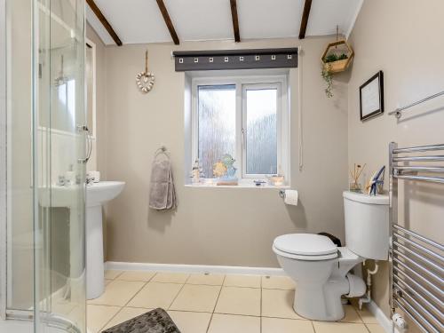 a bathroom with a toilet and a sink and a window at The Lantern Tree in Kingsteignton