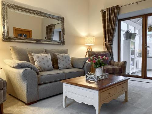 a living room with a couch and a coffee table at Hilton Farm Steadings in Limekilns