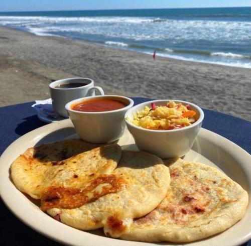 a plate of food with eggs and salsa and two cups at Casa sol Perfect for Families in Santa Ana